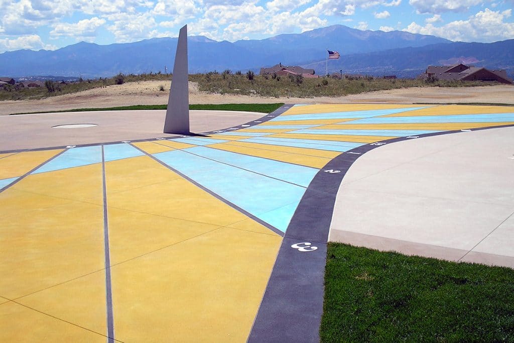Real colored concrete sundial set flush in the ground